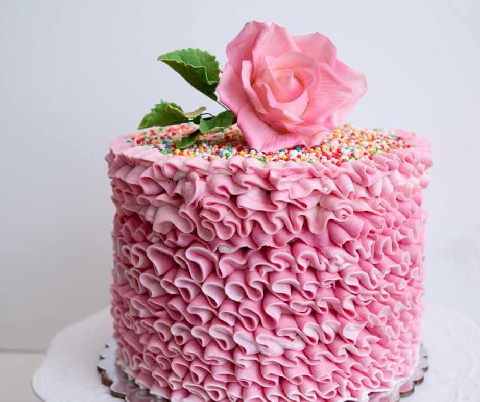 A carrot cake decorated with pink buttercream.