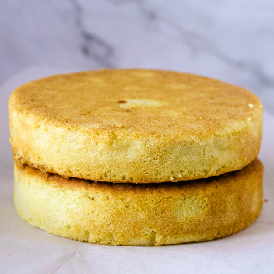 Two vanilla cakes stacked on the table.