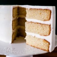 A layer cake decorated with vanilla frosting.