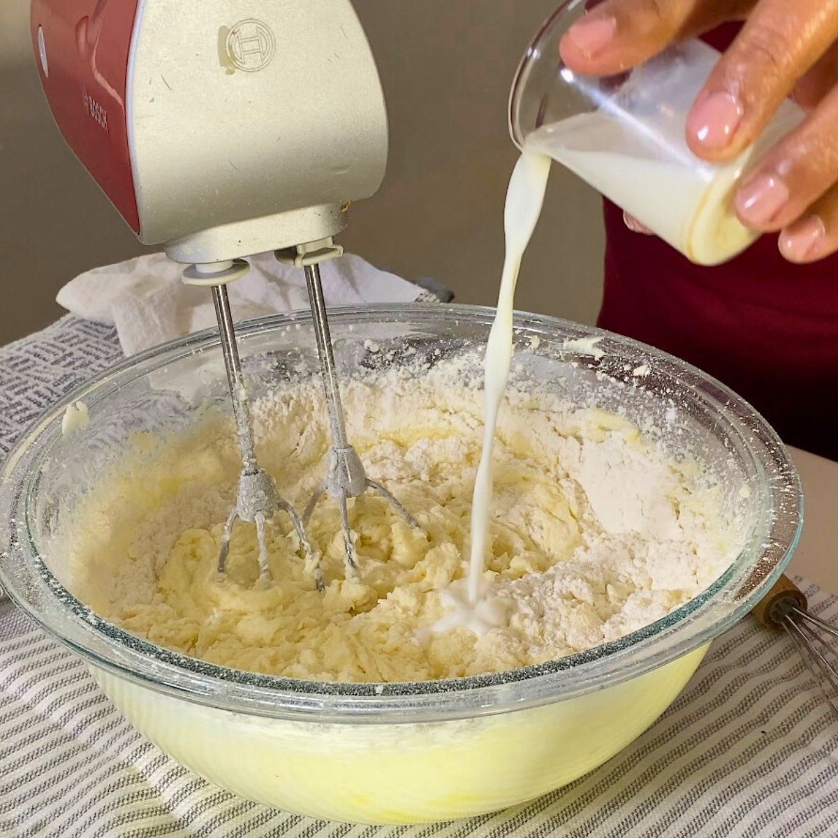 Progress pictures adding milk to the cake batter.
