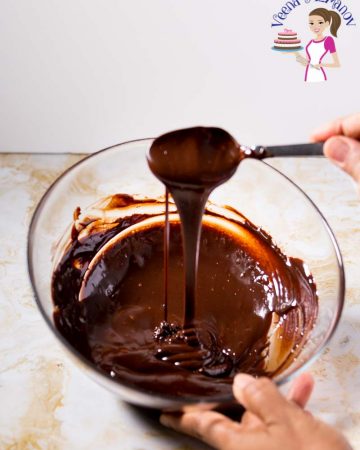 A person melting chocolate in a bowl.