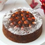 Round fruit cake on a white plate.