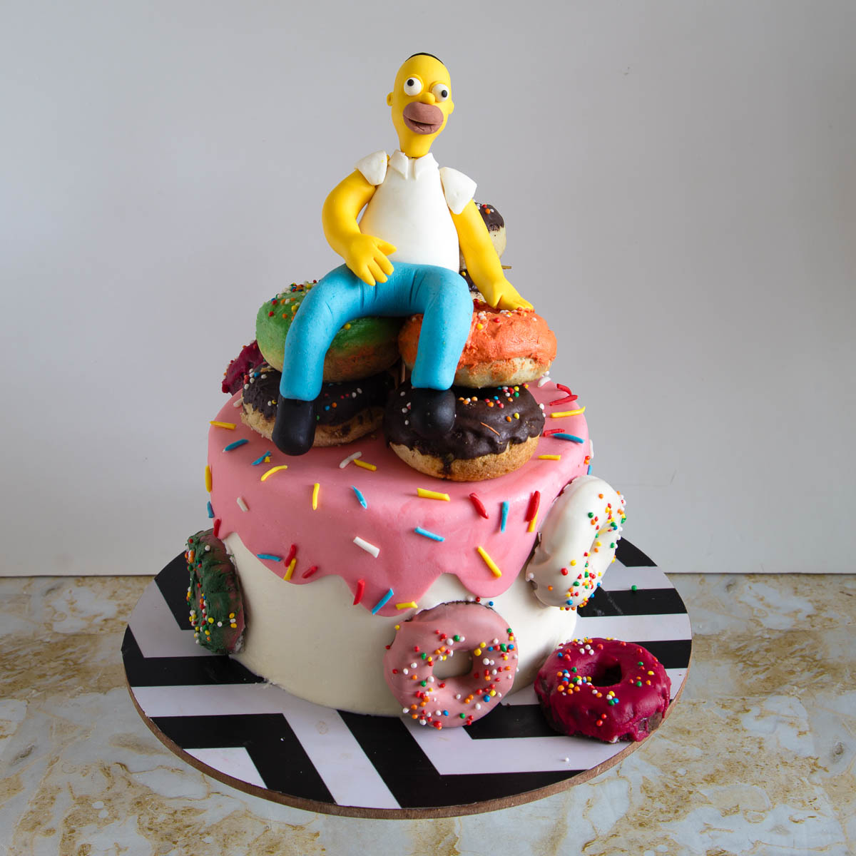 Homer Simpson cake decorated with a pile of donuts and a handmade fondant topper