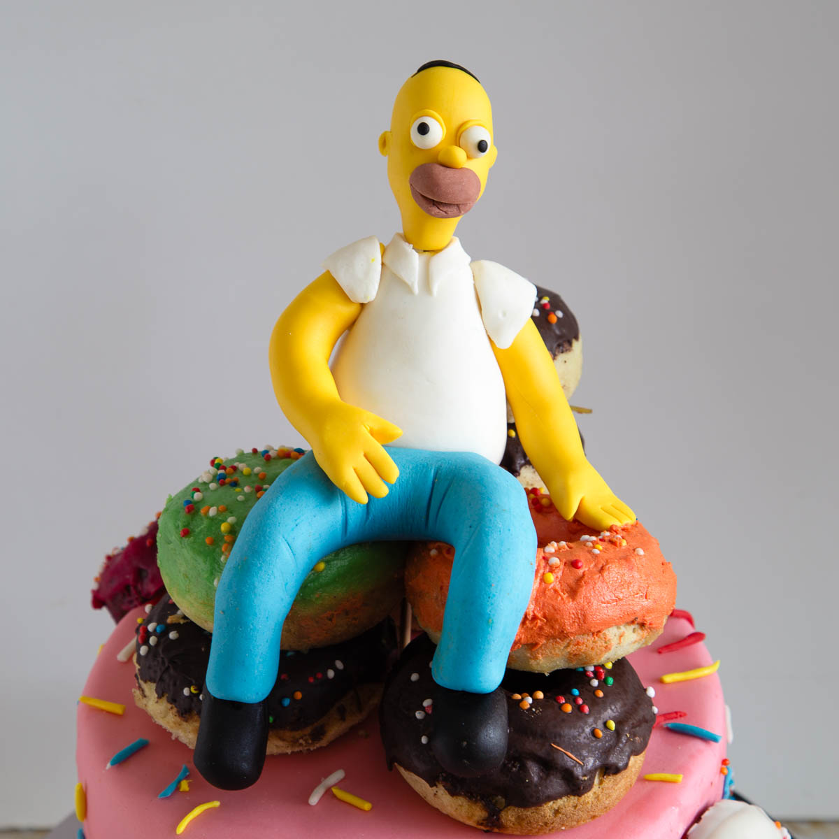 Homer Simpson cake decorated with a pile of donuts and a handmade fondant topper