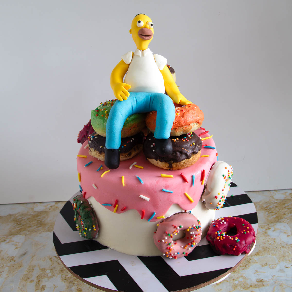Homer Simpson cake decorated with a pile of donuts and a handmade fondant topper
