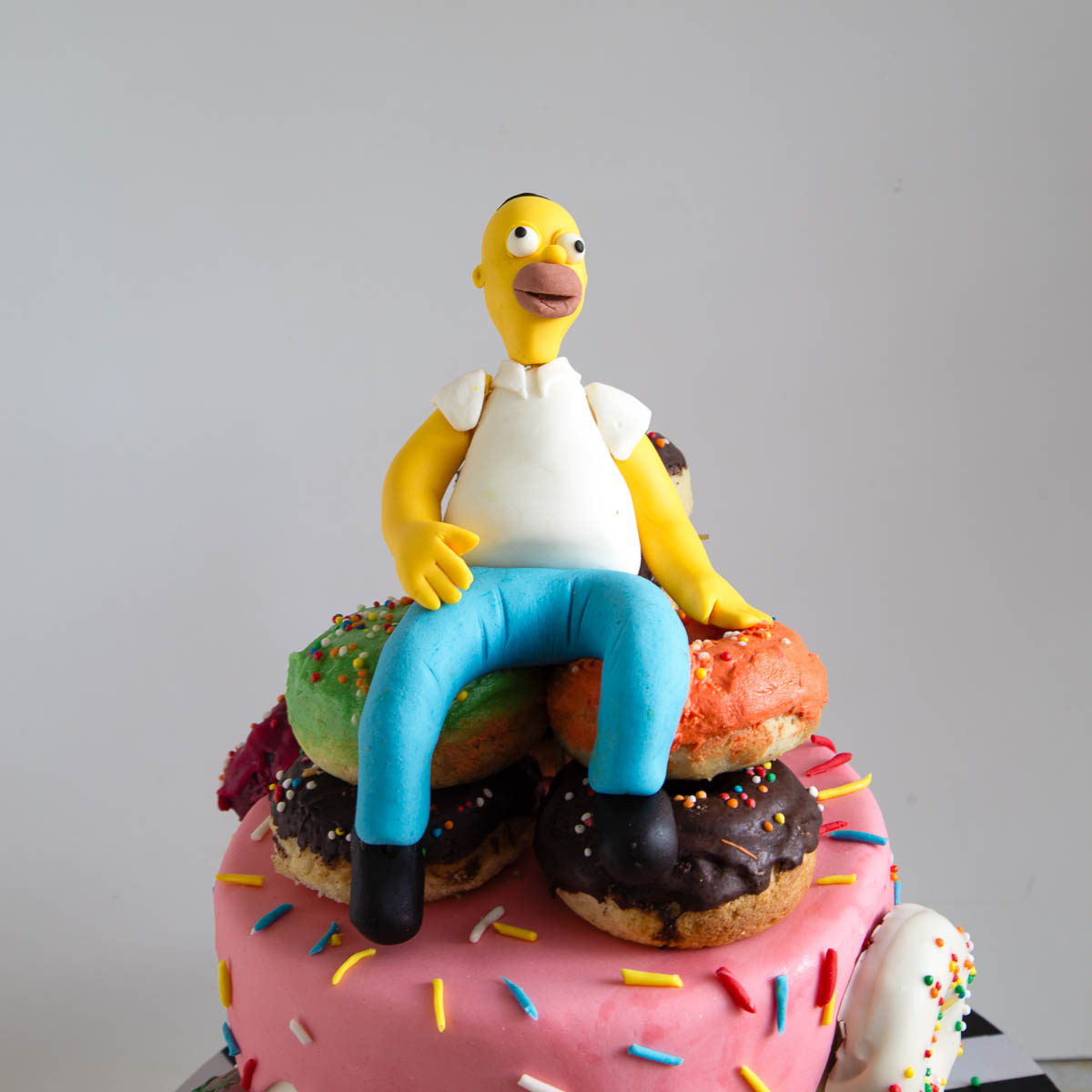 Homer Simpson cake decorated with a pile of donuts and a handmade fondant topper