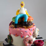 Homer Simpson cake decorated with a pile of donuts and a handmade fondant topper
