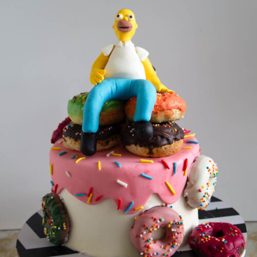 Homer Simpson cake decorated with a pile of donuts and a handmade fondant topper