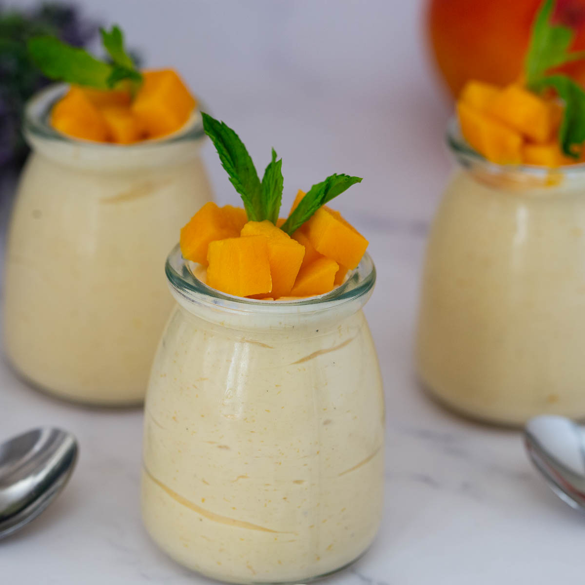 Three jars with mango mousse.