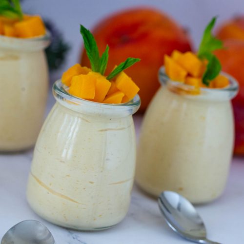 Mango mousse jars with fresh mango cubes.