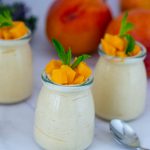 Jars with fresh mango mousse and fresh mango.