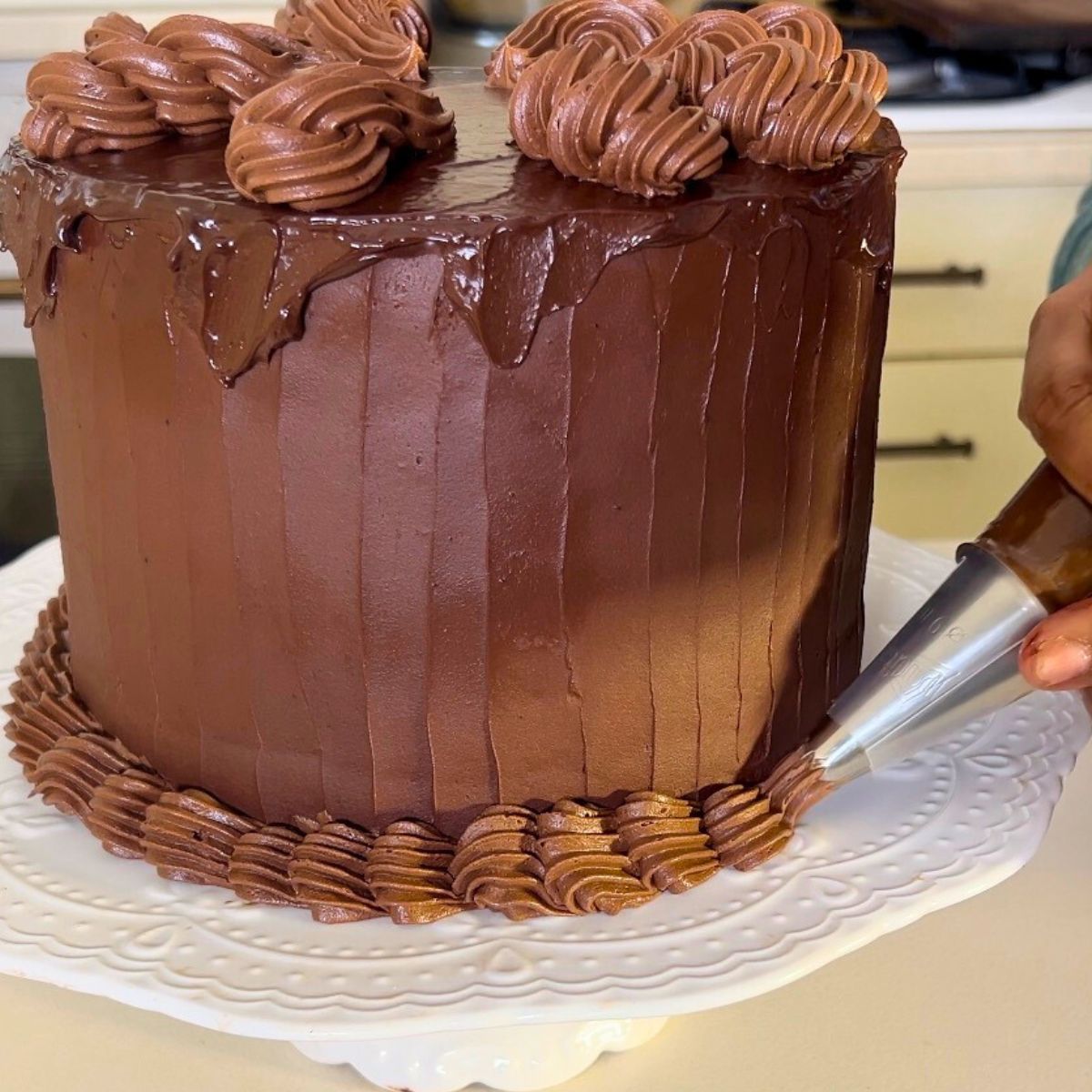 Piping ganache on devils food cake.