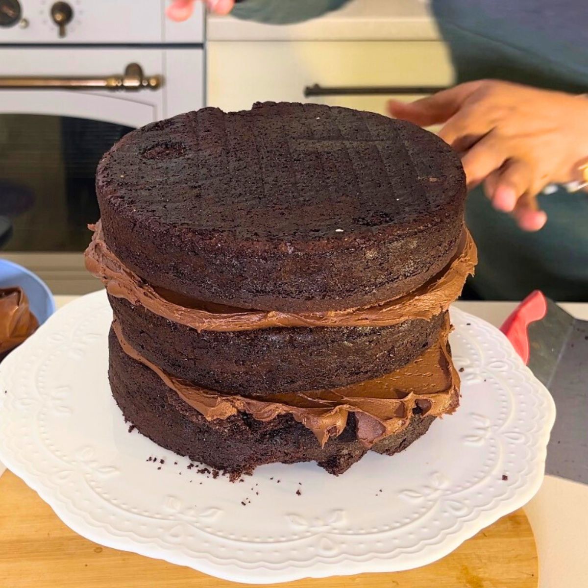 Stacking devils food cake with ganache.