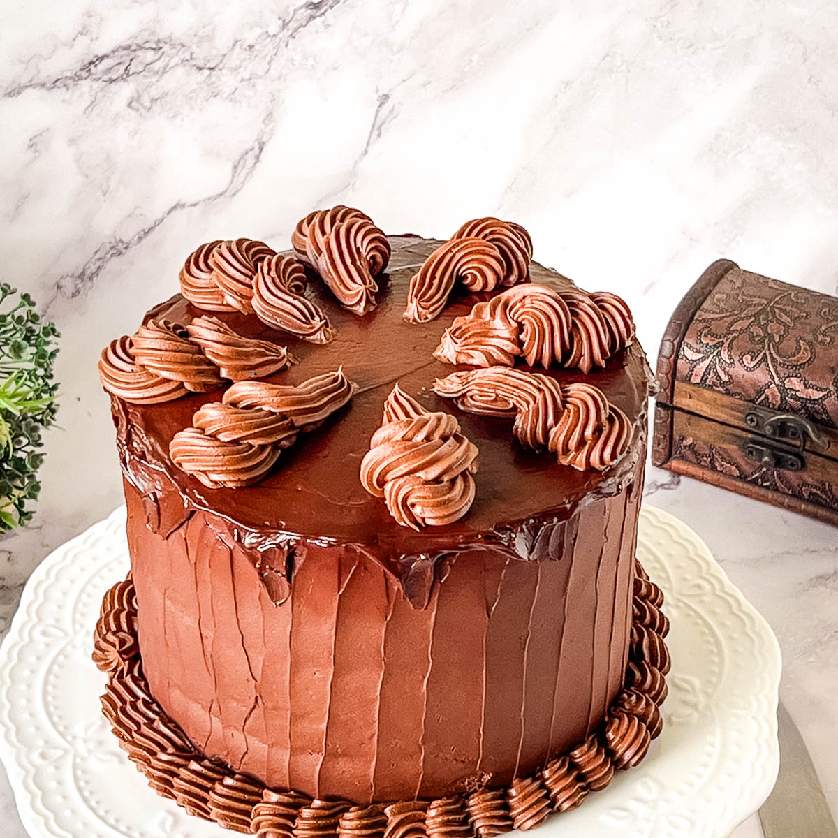 Rich and moist Devil’s Food cake frosted with smooth chocolate ganache for an elegant chocolate dessert.