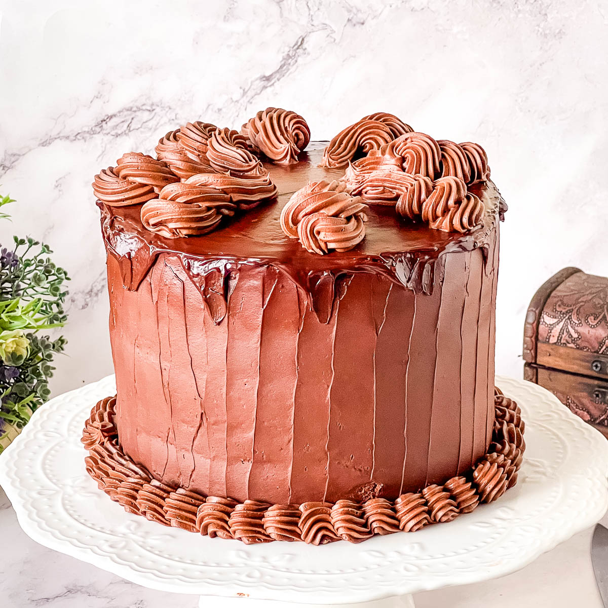 Rich and moist Devil’s Food cake frosted with smooth chocolate ganache for an elegant chocolate dessert.