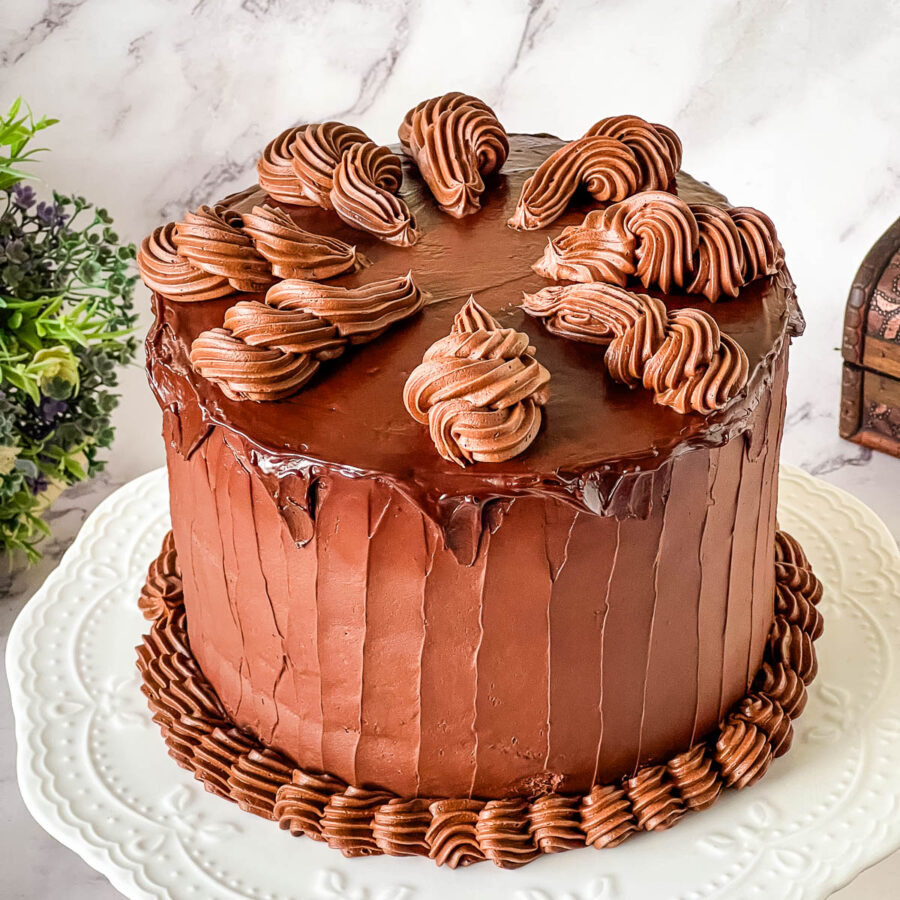 Rich and moist Devil’s Food cake frosted with smooth chocolate ganache for an elegant chocolate dessert.