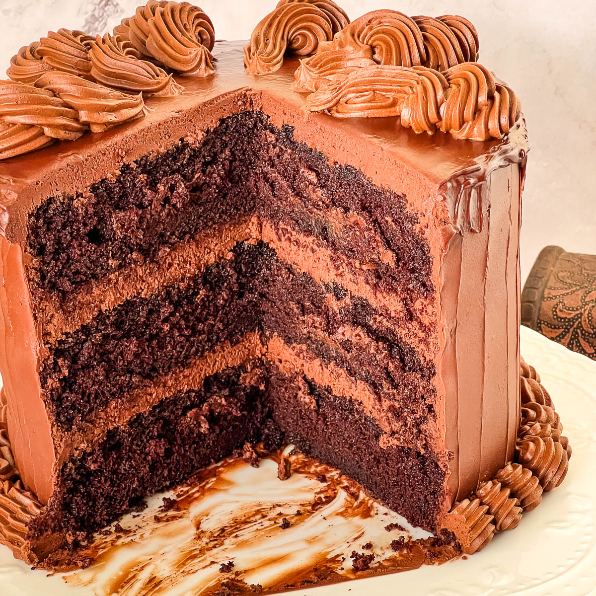 A slice of dark Devil’s Food chocolate cake with a soft crumb and glossy chocolate ganache frosting.