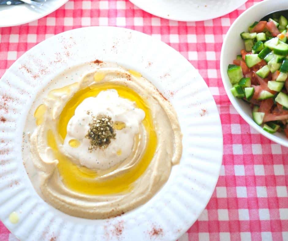 A plate of hummus with olive oil and tahini sauce.