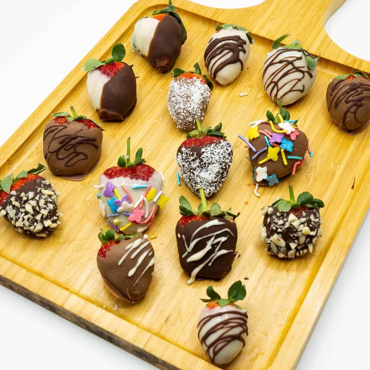 A board with chocolate coated strawberries.