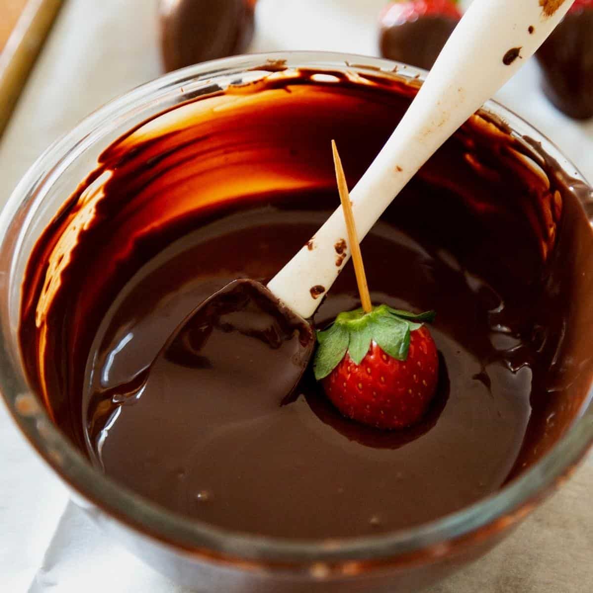 A bowl with melted chocolate and strawberries.