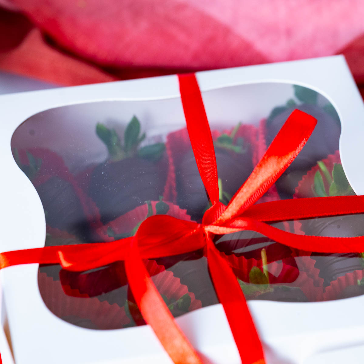 Strawberries covered in chocolate in a gift box.