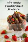 A bowl of chocolate coated strawberries on a table.