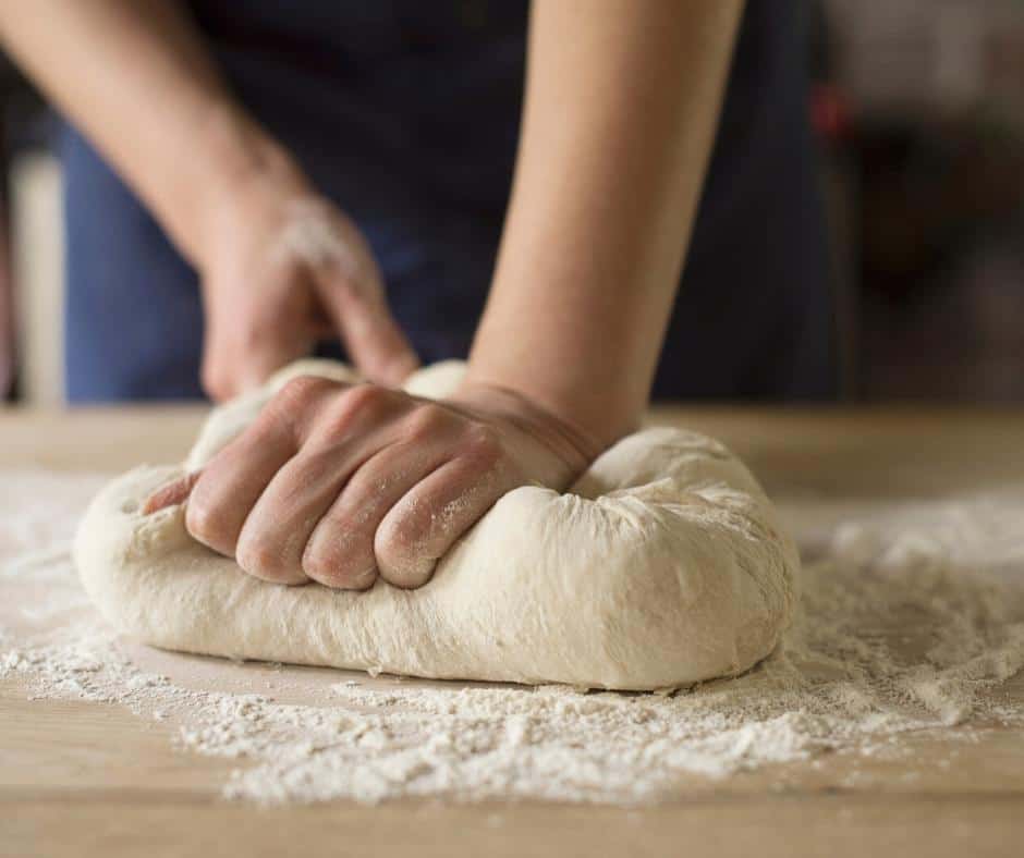A person kneading bread dough.