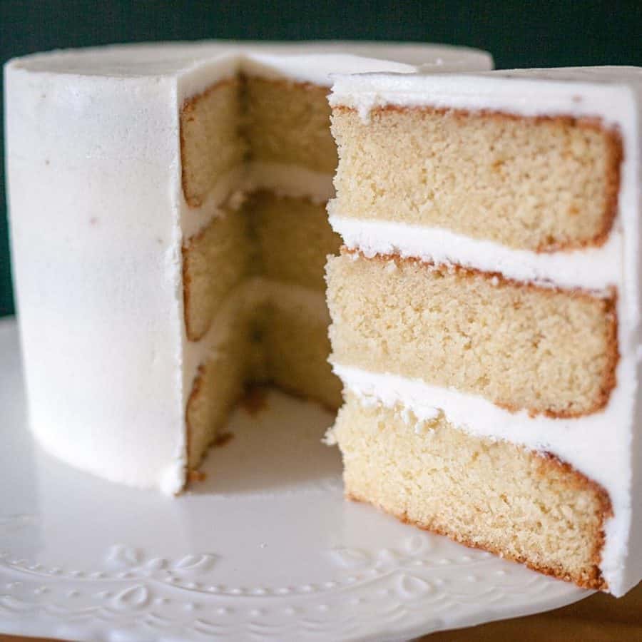 A sliced vanilla cake on a cake stand.