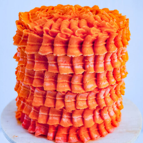 A frosted orange cake on the table.