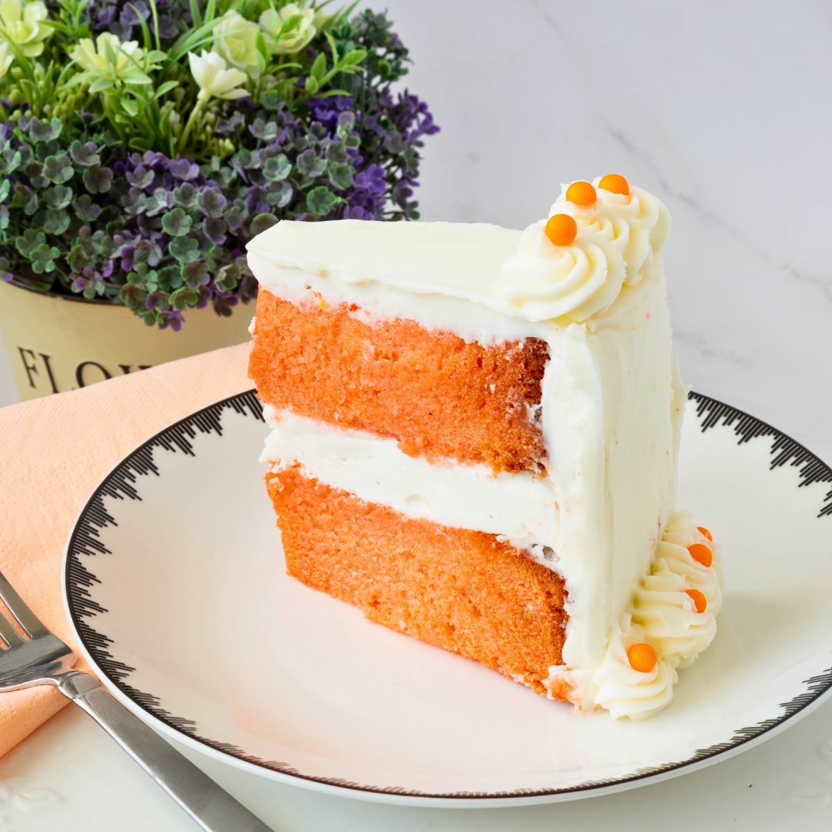 A slice of orange cake on the plate.