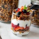 A glass with granola parfait.