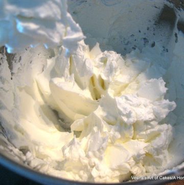 Bowl of a stand mixer with whipped cream.