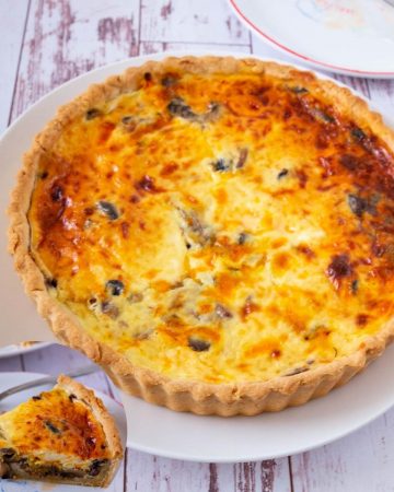 Quiche on a table with mushrooms.
