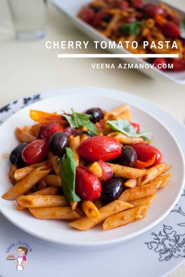 A plate of pasta with cherry tomatoes and olives.