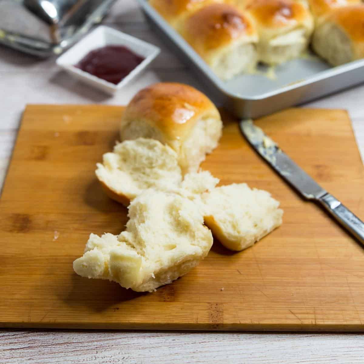 An opened dinner rolls showing the light and fluffy inside.