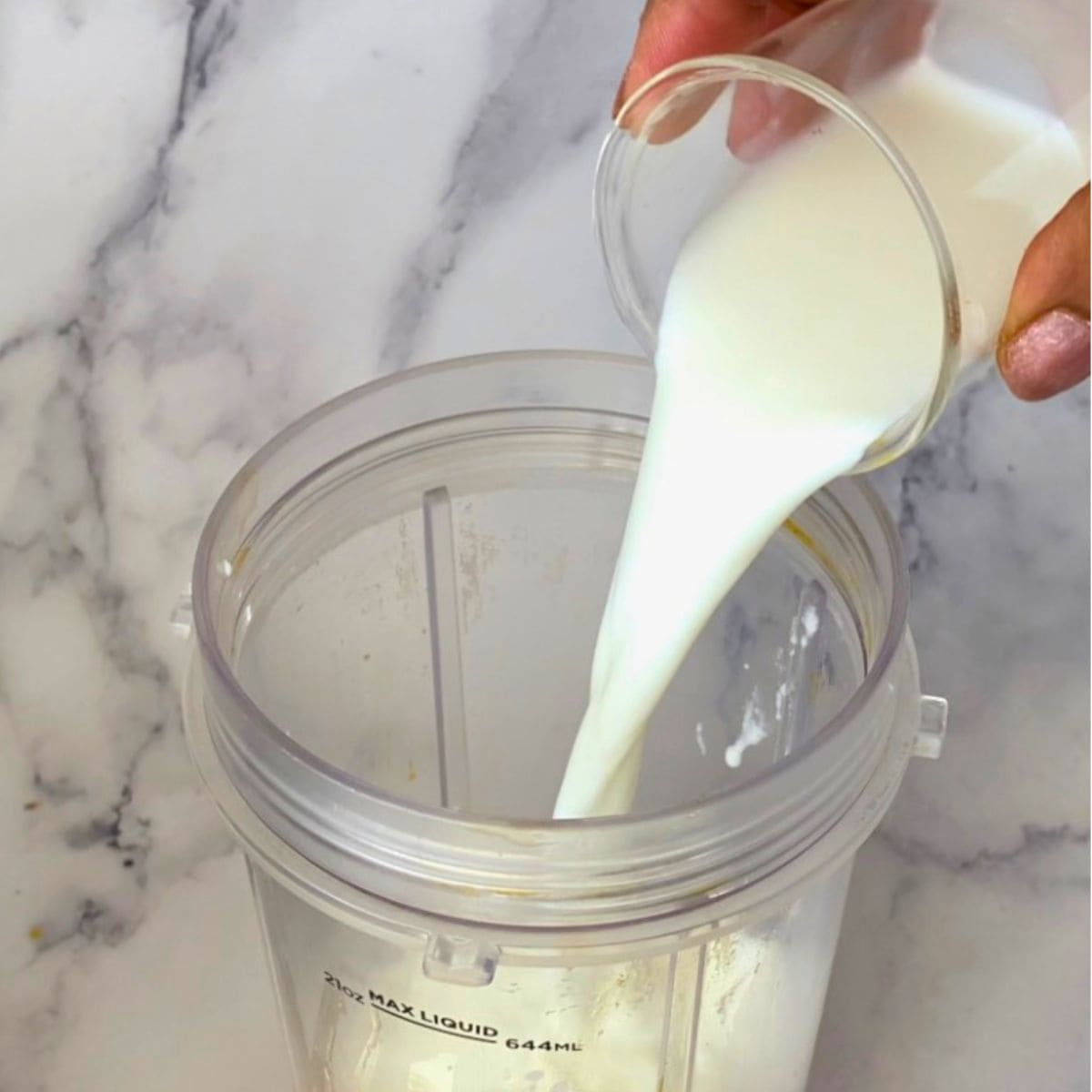 Adding milk to the blender.