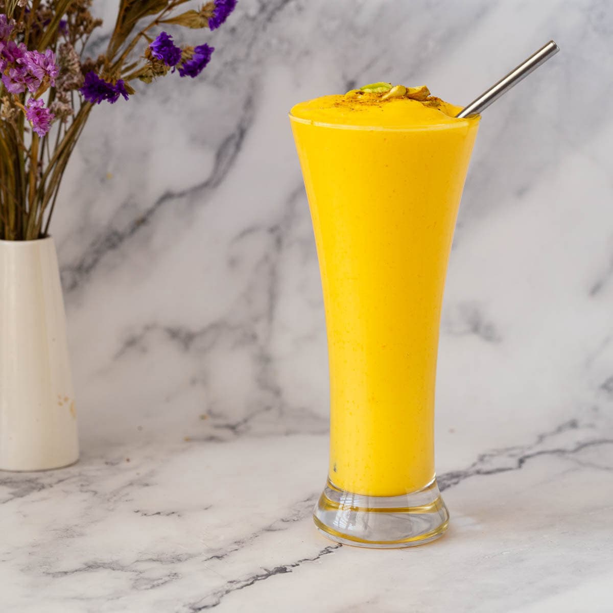 A glass with mango puree, greek yogurt, and milk.