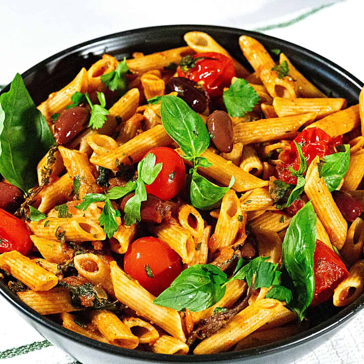 A bowl with pasta and cherry tomatoes.
