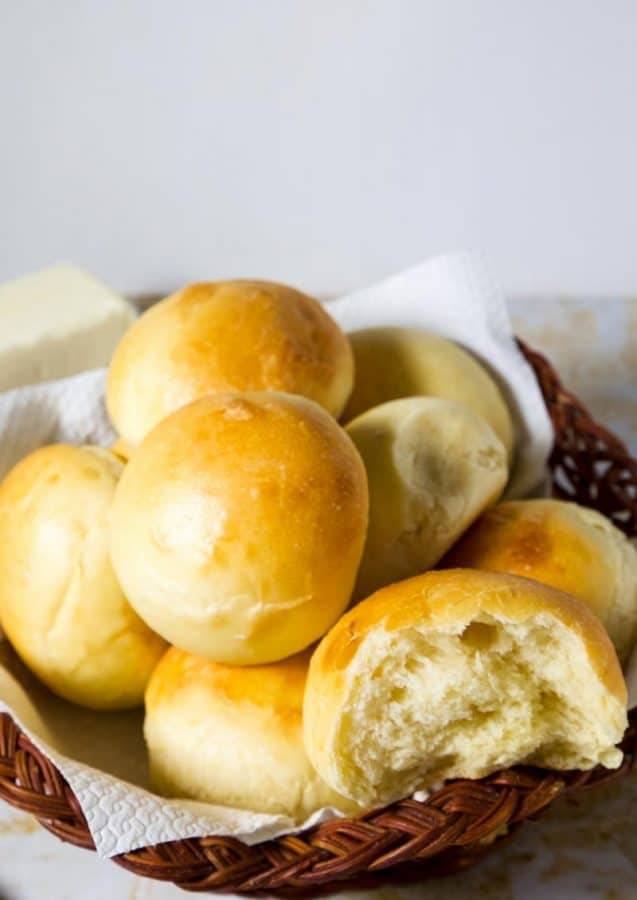 A close up of soft dinner rolls in a basket.