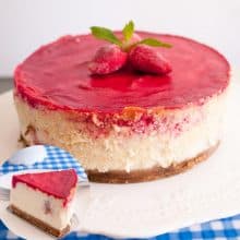 A strawberry cheesecake on a cake stand.