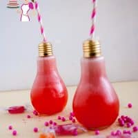 Strawberry lemonade in a glass shaped like a light bulb.
