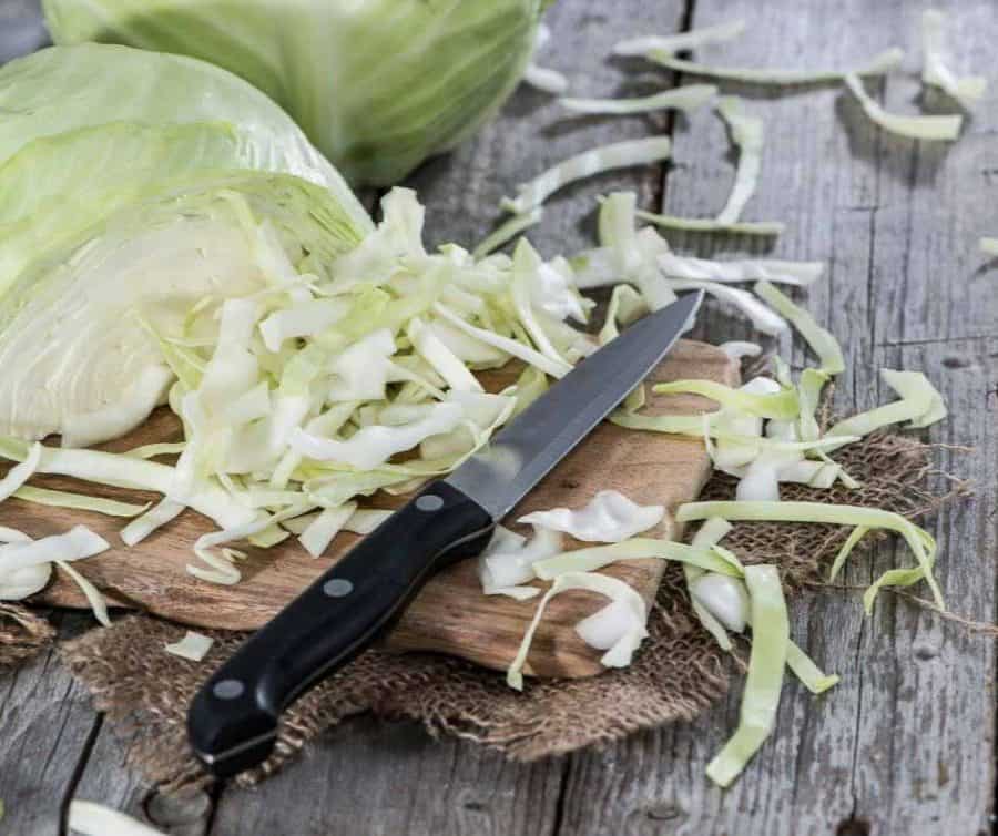 Chopping cabbage with a knife and cutting board.