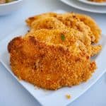 A white plate with schnitzel.