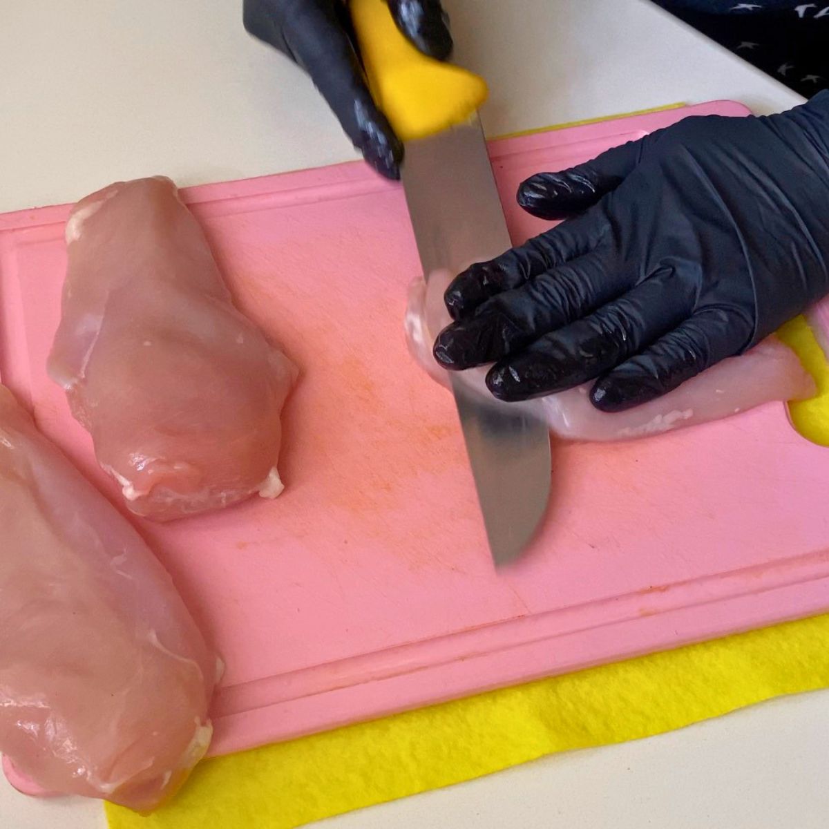 Cutting the chicken breast in half.