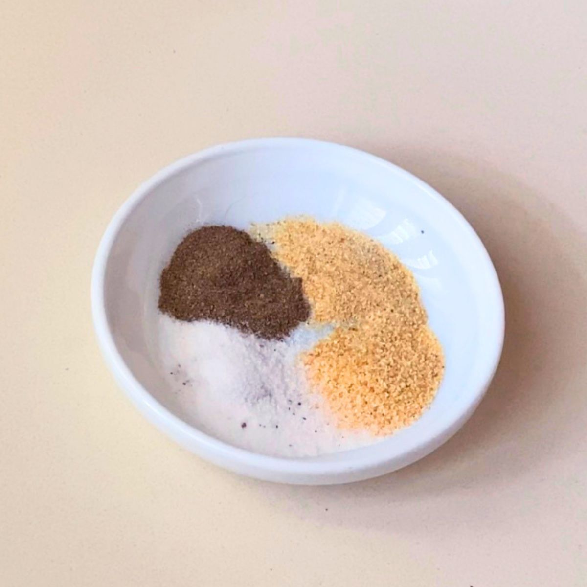 A small saucer with all purpose seasoning.