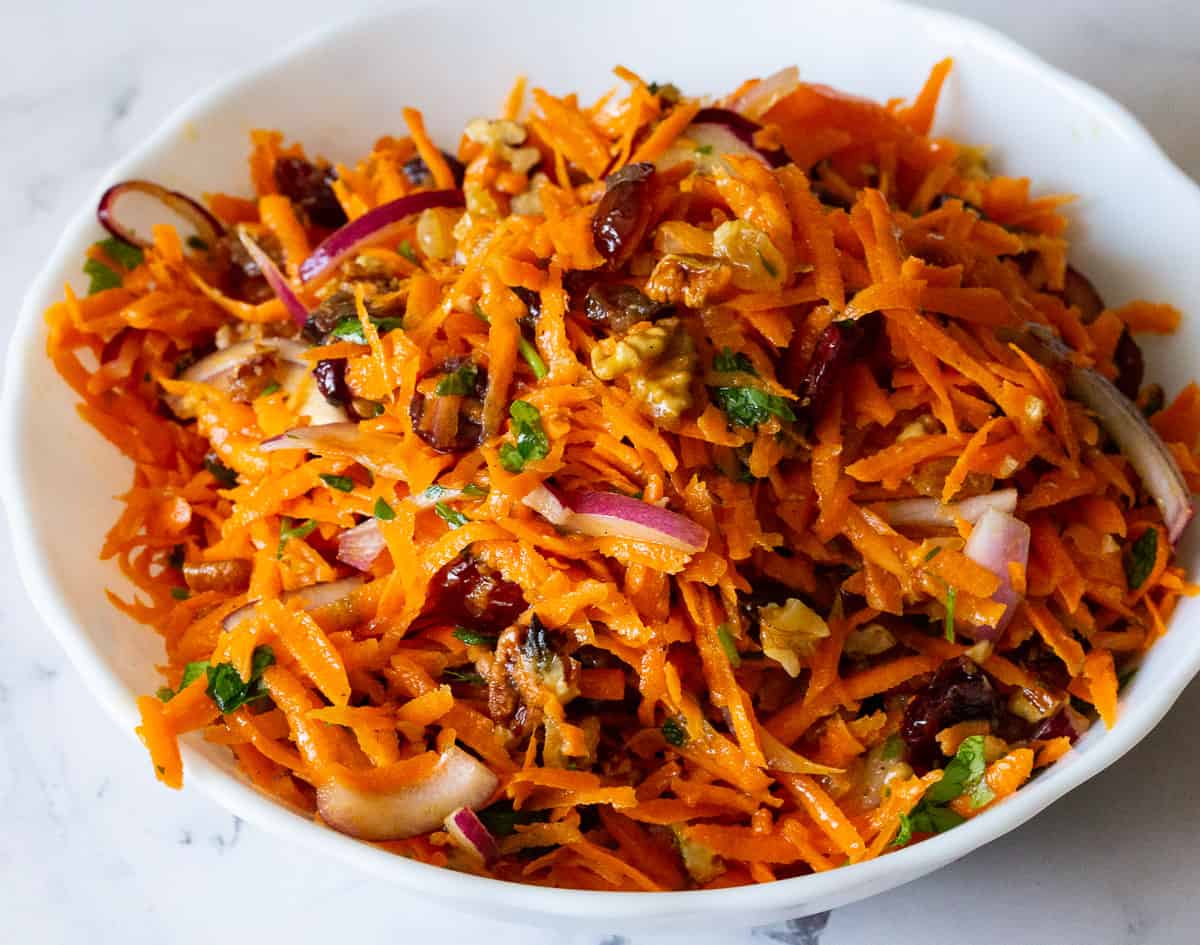 A bowl with grated carrots and salad.