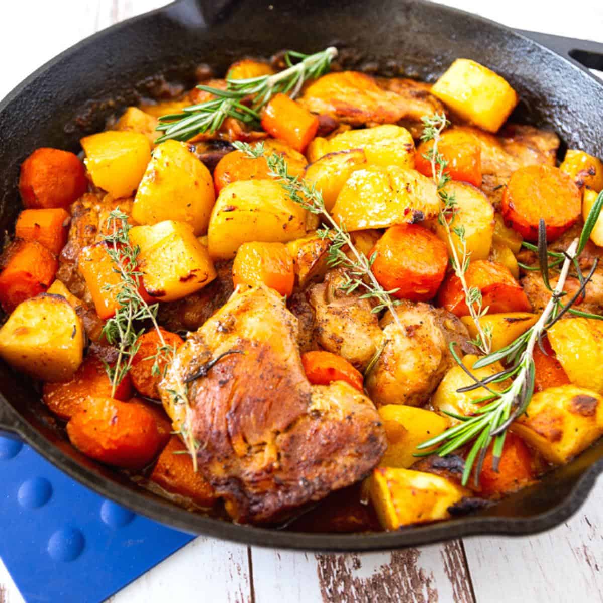 A skillet with roasted veggies and chicken.