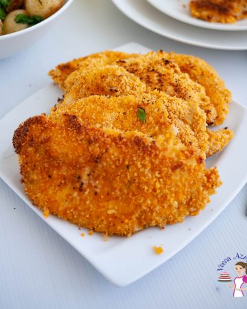 A stack chicken schnitzels on a serving plate.