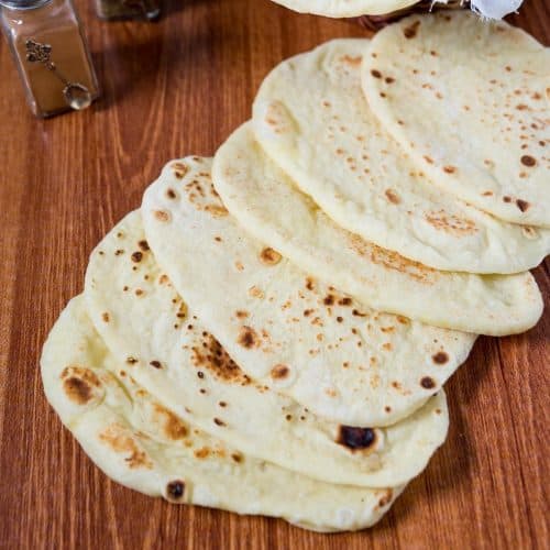 A stack of naan breads on the table.