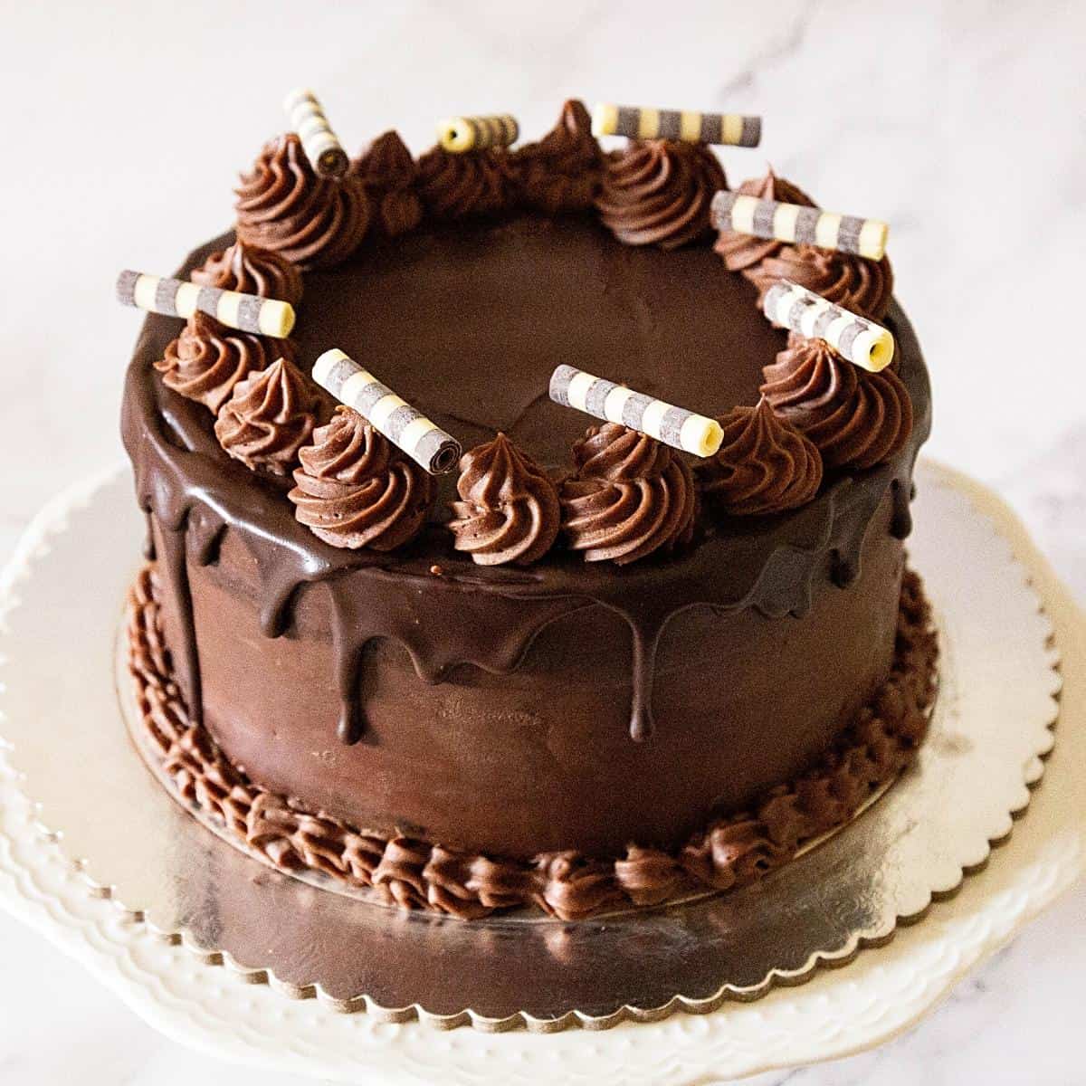 A chocolate cake on a cake board.